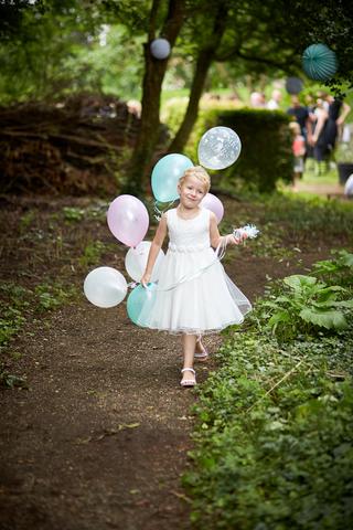 Bloemmeisje Monique met gekleurde ballonnen in Theetuin Explorer, trouwreportage Muiden - Trouwshoot Stefan Segers