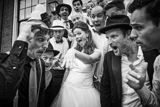 Bruidspaar Rinkje en Wouter omringd door groomsmen en gasten in feestelijke groepsfoto bij Frankendael, trouwreportage Maagde