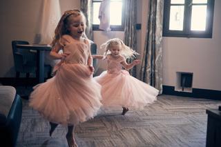 Twee bruidsmeisjes dansen uitgelaten in roze tule jurken in de bruidssuite op Fort Beemster - Trouwshoot Stefan Segers