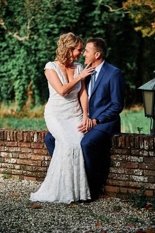 Bruidspaar Marit en Ralph zit intiem op bakstenen muur bij Chateau Marquette Heemskerk, trouwreportage - Trouwshoot Stefan Se