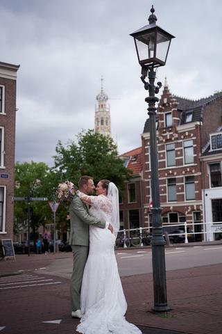 Bruidspaar Liëla en Jeffrey omhelzen elkaar op pleintje Haarlem, romantische trouwreportage Paviljoen Twiske Oostzaan - Trouw