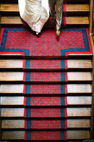 Bruidspaar Angelique en Matthijs loopt op rode loper trappen af - Trouwshoot Stefan Segers