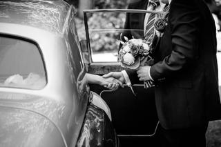 Bruidspaar Linma en Sander stappen uit klassieke trouwauto, eerste moment van hun trouwdag - Trouwshoot Stefan Segers