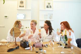 Bruidsmeisjes Rinkje en vrienden klinken met champagne tijdens bridal prep op Frankendael - Trouwshoot Stefan Segers