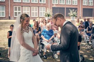 Bruid en bruidegom wisselen trouwbeloften uit onder toezien oog van geliefden op het terras van Fletcher hotel Deurne - Trouw