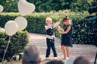 Twee kinderen spelen tussen zeepbellen op het terras tijdens trouwreportage Mike en Ilja - Trouwshoot Stefan Segers