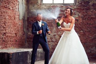 Bruidspaar Aniek en Nick poppen champagne in de historische bakstenen loods van Villa de Vier Jaargetijden - Trouwshoot Stefa
