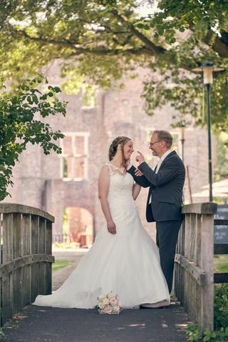 Bruidspaar Ilja en Mike op houten brug bij Klein kasteel Deurne, romantische trouwreportage Fletcher Hotel Deurne - Trouwshoo