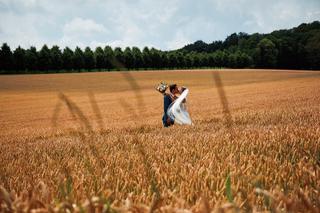 Bruidspaar Niels en Karien kussen in graanveld bij Villa Dalhof Berg en Dal, romantische trouwreportage - Trouwshoot Stefan S