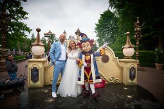 Annemarie en Jan poseren met een sprookjesfiguur voor het kasteel in de Efteling tijdens hun bruiloft - Trouwshoot Stefan Seg