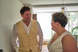 Tijdens de bruiloft van Froukje en Mireille in Blizz Boekel: een moment vol lachen en warmte tussen bruidegom en gast - Trouw