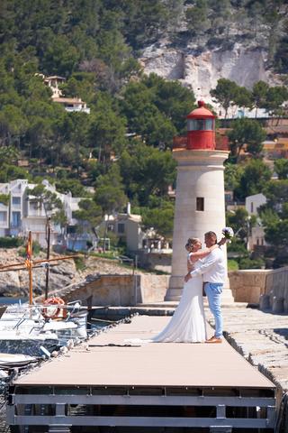 Bruidspaar Stephanie en Wesley op steiger Villa Italia Andratx Mallorca, vuurtoren achtergrond - Trouwshoot Stefan Segers