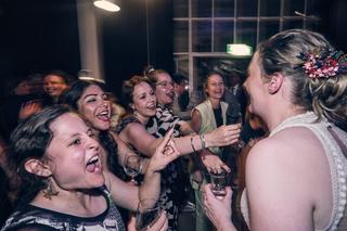 Bruid Simanca danst lachend met vriendinnen tijdens het feest in Huszár Delft, blije momenten op de bruiloft - Trouwshoot Ste
