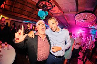 Bruidegom Patrick en gasten dansen uitgelaten op trouwfeest Ter Aard Delft, festive bruiloft sfeer met neonverlichting - Trou