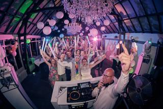 Bruidspaar Evelien en Krijn feesten met gasten in verlichte tent, DJ De Vriendelijke aan decks, trouwfeest De Schaapskooi Del