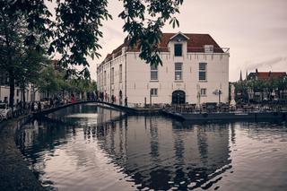 Simanca en Harm-Jan aan het kanaal in Delft met het elegante Huszár op de achtergrond - Trouwshoot Stefan Segers