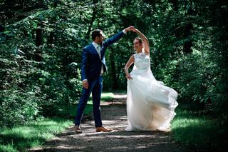 Bruidspaar Tessa en Jeroen dansen in groene bospark, bruidsjurk wappert, trouwreportage Het Rieten Dak Delftse Hout - Trouwsh