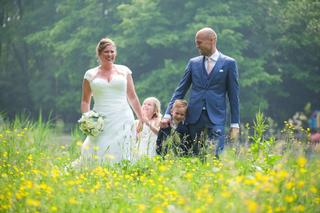Bruidspaar Deborah en Remco wandelt met kinderen door bloemenweide, trouwreportage Delftse Hout Delft - Trouwshoot Stefan Seg