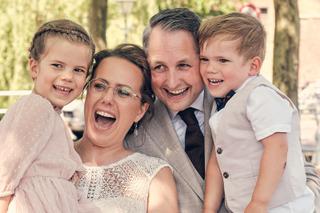 Bruidspaar Evelien en Krijn met kinderen lachend bij trouwerij De Schaapskooi Delft, gelukkig familieportret - Trouwshoot Ste