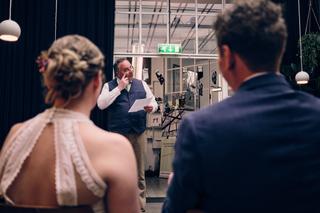 Bruidegom Harm-Jan spreekt tijdens receptie in Huszár Delft, bruidsmeisje luistert aandachtig - Trouwshoot Stefan Segers