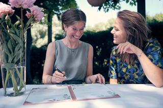 Bruidspaar Evelien en Krijn ondertekent trouwcontract in tuin De Schaapskooi Delft, romantische bruidsfotografie - Trouwshoot