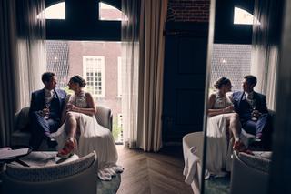 Bruidspaar Harm-Jan en Simanca in intiem moment bij raam Hotel Arsenaal Delft, trouwreportage stadhuis Delft - Trouwshoot Ste