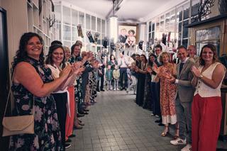 Bruidspaar Harm-Jan en Simanca loopt door spiesegang stadhuis Delft, gasten applaudisseren bij trouwreportage Hotel Arsenaal
