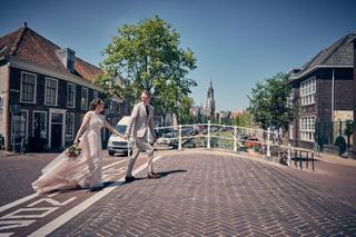 Bruidspaar Evelien en Krijn loopt hand in hand door historische straat Delft, trouwreportage De Schaapskooi - Trouwshoot Stef