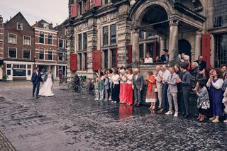 Bruidspaar Harm-Jan en Huszár op Markt Delft bij stadhuis, trouwreportage met gasten - Trouwshoot Stefan Segers