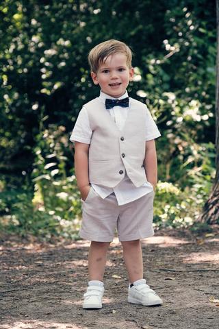 Pageboy Krijn in elegant wit pak met vlinderstrik, trouwreportage Evelien en Krijn in De Schaapskooi Delft - Trouwshoot Stefa