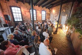 Bruidspaar ceremonie in Torpedoloods Schiedam, gasten in industrieel trouwlocatie, trouwreportage - Trouwshoot Stefan Segers