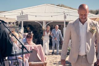 Bruidspaar Chris en Gerco ceremonie strand Strandclub Naturel Scheveningen, gasten op zand, trouwreportage - Trouwshoot Stefa