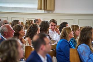 Bruidegom Tom glimlacht naar gasten tijdens de ceremonie in de kerk - Trouwshoot Stefan Segers