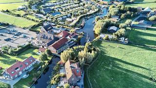 Luchtfoto van bruidspaar Patrick en Lyn bij Meerhoeve in Oud Ade, met pittoresk Nederlands landschap en kanalen - Trouwshoot