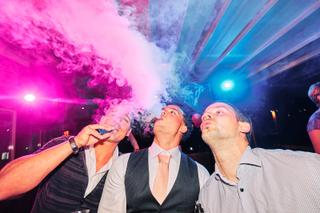 Bruidegom Stefan en gasten vieren feest met champagne onder roze en blauwe neon-verlichting, trouwreportage Waterreus - Trouw
