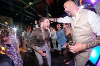 Bruidspaar en gasten dansen uitgelaten op trouwfeest Sodafabriek Schiedam, feestelijke trouwreportage met DJ en colorato lich