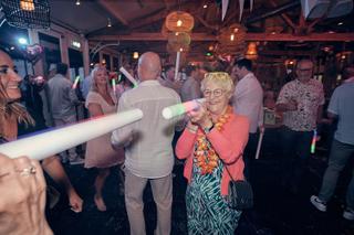 Bruidspaar Silvia en Patrick dansen met gasten op trouwfeest in Beachhouse Kijkduin Den Haag, bruidsfotografie - Trouwshoot S