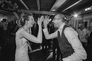 Bruidspaar Ilse en Robbert dansen vrolijk op trouwerij Boerderij Burgersdijk De Lier, swingend moment trouwreportage - Trouws
