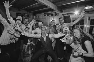 Bruidspaar Ilse en Robbert met gasten op dansfeest, vrolijke trouwreportage Boerderij Burgersdijk De Lier - Trouwshoot Stefan