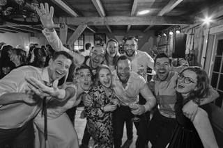 Bruidspaar Ilse en Robbert feest uitbundig met gasten in schuur Boerderij Burgersdijk De Lier, trouwreportage - Trouwshoot St