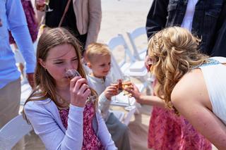 Kinderen proostend met drankjes op het terras van Beachclub Titus tijdens de bruiloft van Elise en Erik - Trouwshoot Stefan S