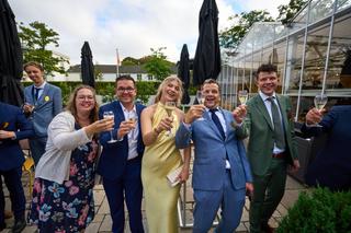 Emmely en Tom tosten met gasten op het terras van Villa Ockenburgh - Trouwshoot Stefan Segers