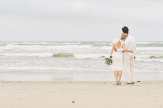 Bruidspaar Annemieke en Jaap op het strand van Kijkduin, verliefd moment in bruidsjurk en pak bij de zee, trouwreportage - Tr