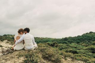 Bruidspaar Annemieke en Jaap zittend op zandduinen bij Kijkduin, romantische trouwreportage - Trouwshoot Stefan Segers