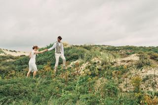 Bruidspaar Annemieke en Jaap dansen in duinen van Kijkduin, trouwreportage met natuurlijke sfeer - Trouwshoot Stefan Segers