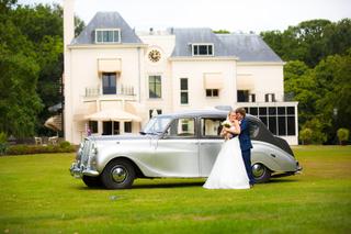 Bruidspaar Liselotte en Matthijs in klassieke auto voor Landgoed Te Werve, romantische bruidsfotografie Oud Rijswijk - Trouws