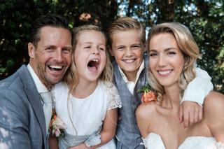 Gelukkig bruidspaar Carlo en Lucinda met kinderen lachen samen in tuin Kasteel Sypesteyn Loosdrecht, familieportret trouwdag
