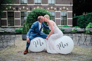 Bruidspaar Johan en Marion kussen op ballonnen met Mr & Mrs bij Vlietzigt Rijswijk - Trouwshoot Stefan Segers
