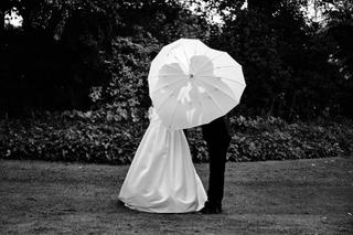 Bruidspaar onder witte parasol in het park van kasteel Duivenvoorde, romantisch zwart-witportret - Trouwshoot Stefan Segers