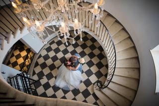 Bruidspaar Danielle en Richard in Witte Huis, luchtfoto trouwreportage op marmeren trap met kroonluchter - Trouwshoot Stefan
